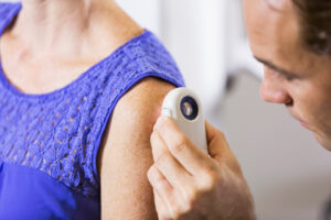 Dermatologist examining patient's skin